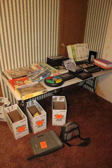 X-Acto Paper Cutter, Monopoly Games, Jigsaw Puzzles, Board Games, Wii Fit Board, Cassette Case, Cassettes, Sony Cam Recorder, Oculus VR Headset and Remote, and Misc. image