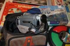 X-Acto Paper Cutter, Monopoly Games, Jigsaw Puzzles, Board Games, Wii Fit Board, Cassette Case, Cassettes, Sony Cam Recorder, Oculus VR Headset and Remote, and Misc.