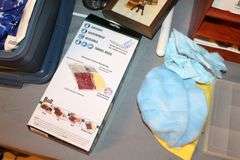 (2) Plastic Covered Trays, Plastic Bins, Plastic Tote, White Plastic End Table, Super Sliders, 3 Drawer Cubby, Fabric, and Misc.