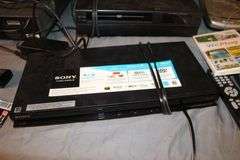 Daewoo VHS Player, Arris HDMI Box, Sony Blu Ray Player, VHS Player, TV Remotes, Candles, Kinyo VHS Tape Player, Protron DVD Player, Iron, and Misc.
