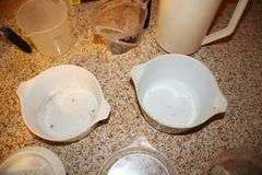 Pyrex Mixing Bowls, Plastic Measuring Cups, Glass Bowls, Strainer, (2) Sifters, Biscuit Cutters, and Misc.