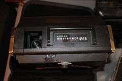 DVD Cases, Belmont Binoculars, Kodak Record Player, DVD Player, Clock Radio, Headphones, Camera Bag, and Misc.