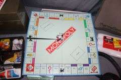 Metal Box, Monopoly Board Game, Extension Cords, Envelopes, (2) Plastic Baskets, Paint Roller, Office Supplies, and Misc.