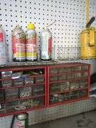 Contents of small shelf, nuts and bolts organizer, lube cans, oil can, belts