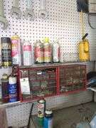 Contents of small shelf, nuts and bolts organizer, lube cans, oil can, belts