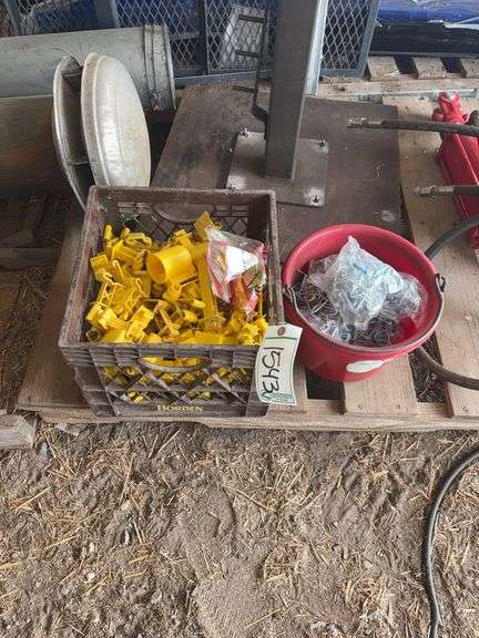 Tote of T-post insulators & bucket full of T-post retainers, bldg:green image
