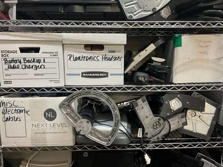 Box of Battery Backups & Radio Chargers, Box Of Plantronics Headsets, Soldering Gun, 2 Docking Stations, Monitor Stand, Monitors, Box of Power Cords, Box of Misc. Electronic Cables, HP Scanjet 3970, Working Condition Unknown