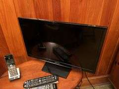 Flat screen TV, tall lamp and side table