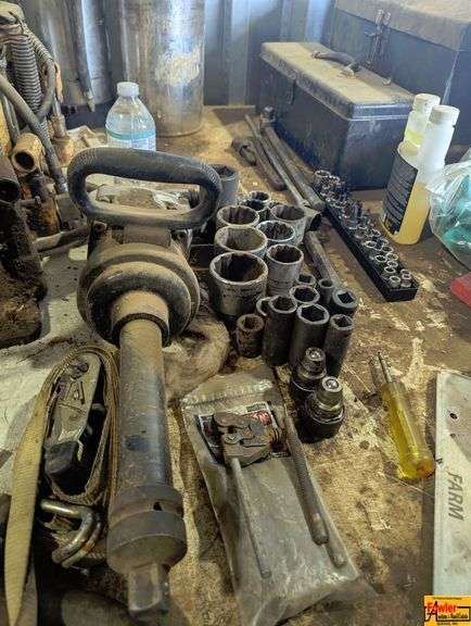 Work Table With Contents:  Heavy Duty Impact Wrench, Sockets, Toolboxes, Bottle Jacks, Fire Extinguishers, Large C-Clamp & More image