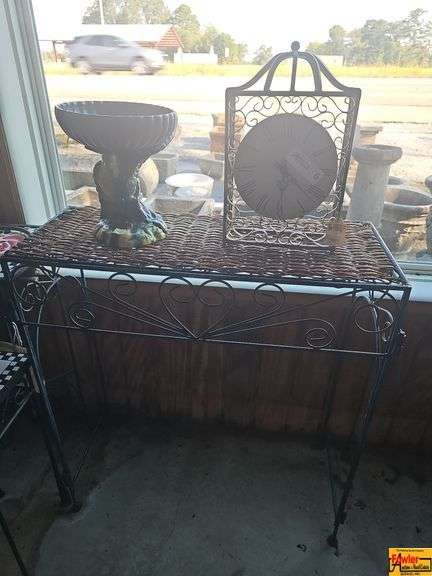 Decorative Clock and Urn on Wicker-Top Metal Table image