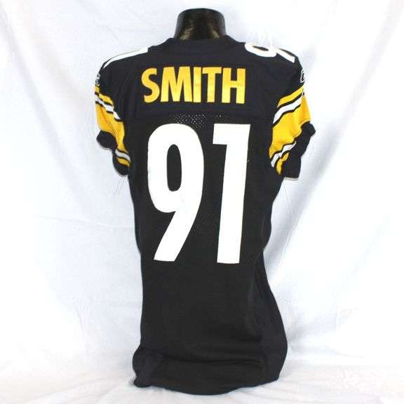 Pittsburgh Steelers #91 Aaron Smith Game Used Home Jersey. Reebok jersey used by defensive lineman Aaron Smith. Jersey has a 2008 year tag. Jersey has several team repairs, custom tailoring, scrapes, loose threads and other signs of wear. Smith is a two-time Super Bowl Champion (XL & XLIII) and made the Pro Bowl once (2004). Each autographed and game-used item is personally authenticated by Pittsburgh Steelers Authentic Memorabilia. Each memorabilia item is affixed with an individually numbered, tamper-evident hologram or vinyl patch which can be verified online ensuring that this item is authentic and eliminating the possibility of fraud. image