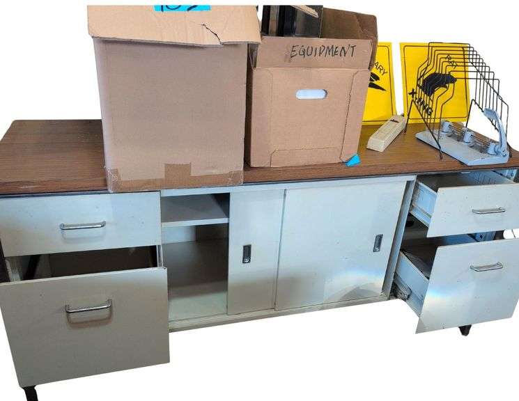 Filing Cabinet Credenza. Paper Punch. Adding Machine with Tape.  Metal Bookends. Paper Trays and Rack. Large Binders. Multi Plug. 2 Yellow Signs. image