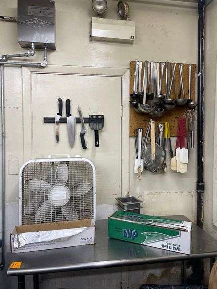 Utensiels on Wall along with Fan and Box of Cling Wrap