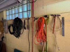 All Items on Right Hand Wall of Garage, Including Hoses, Rakes, Brooms, Shovels, Extension Cord, Creeper, Rope, Buckets, Watering Cans