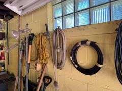 All Items on Right Hand Wall of Garage, Including Hoses, Rakes, Brooms, Shovels, Extension Cord, Creeper, Rope, Buckets, Watering Cans