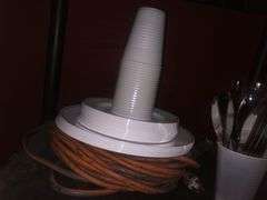 Black Plastic Cart Without Wheels, Plastic Cups, Plates, and Utensils, Various Kitchen Utensils, Extention Cord, Paper Towels