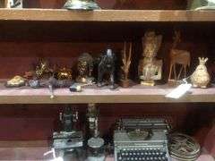 Various Decorative Items Including Faux Flower, Skull Wall Piece, Stick Dummy, 2 Head Figurines, Elephant Statue, 2 Antelope Statues, Golden Pumpkin, and Bird with Crown Statue