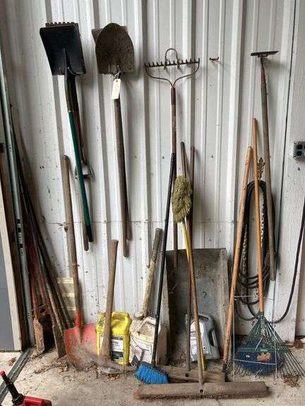 Contents of Wall Including Shovels, Brooms, Spud Bars, Pickax, and Rakes image