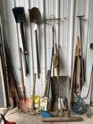 Contents of Wall Including Shovels, Brooms, Spud Bars, Pickax, and Rakes