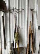 Contents of Wall Including Shovels, Brooms, Spud Bars, Pickax, and Rakes