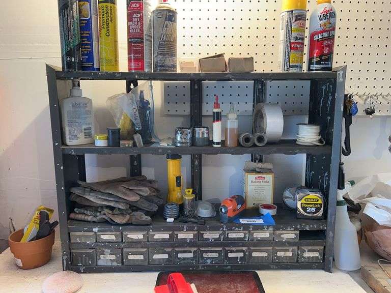 Tool organizer shelf includes assortment bin with some hardware plus tape measures, gloves, laser level, chalk line