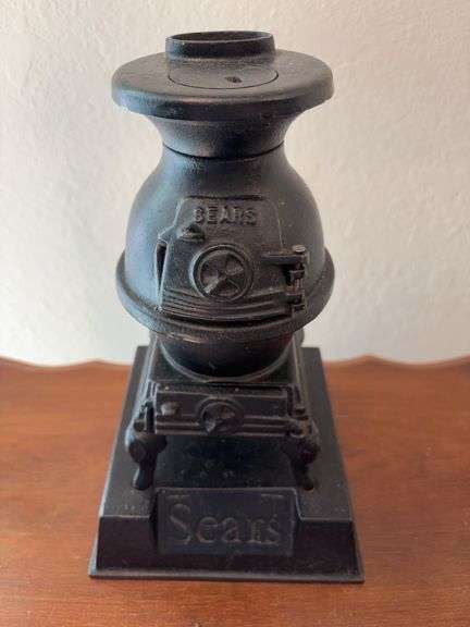 Sears mini cast iron pot belly stove, probably display item 10" tall on a base marked Sears image