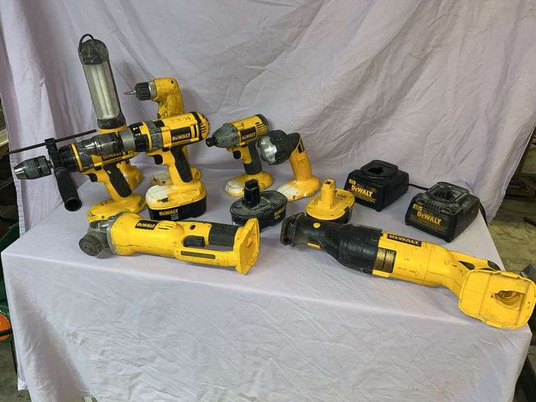 Dewalt 18 volt volt tools, two dead batteries, two chargers, impact driver, drill/driver, right angle drill driver, two hammer drills, cutoff tool, DC385 reciprocating saw. Fluorescent area light, small light on shelving. image