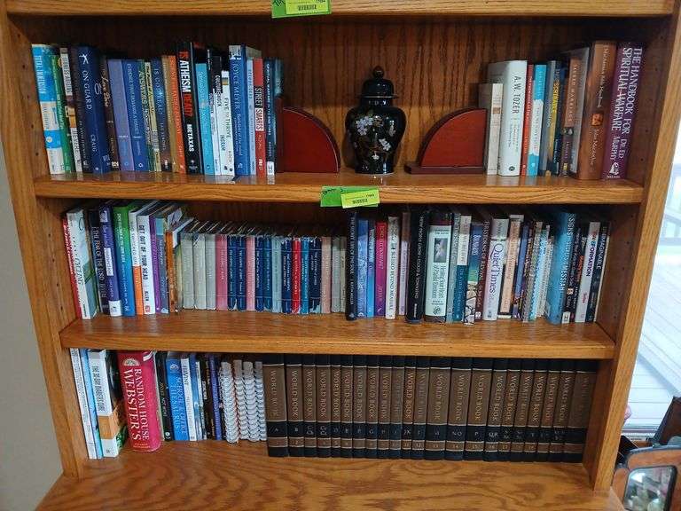 Three shelves of books includes religious and World Book encyclopedias image