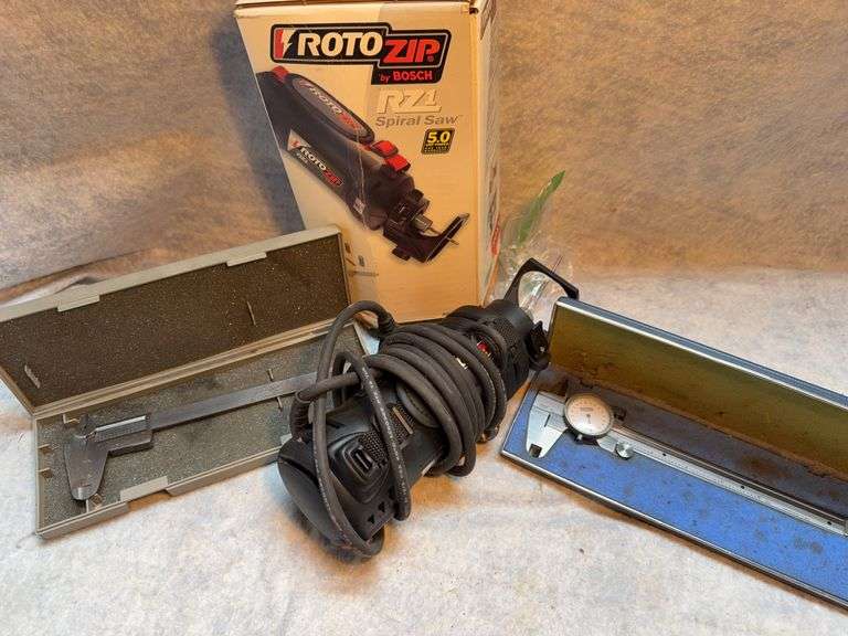 Old tools in fruit box tote, 6-in Craftsman dial caliper, 6-in Sears vernier caliper, rotozip RZ spiral saw with bits. image