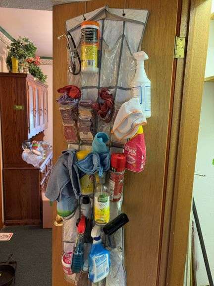 Wire racks, shower curtain rods, duster, Scentsy cubes and other cleaning supplies on door image