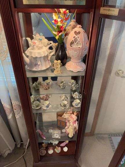 Contents of clock shelves includes Avon egg shaped pink music box, shoes, doll, etc image