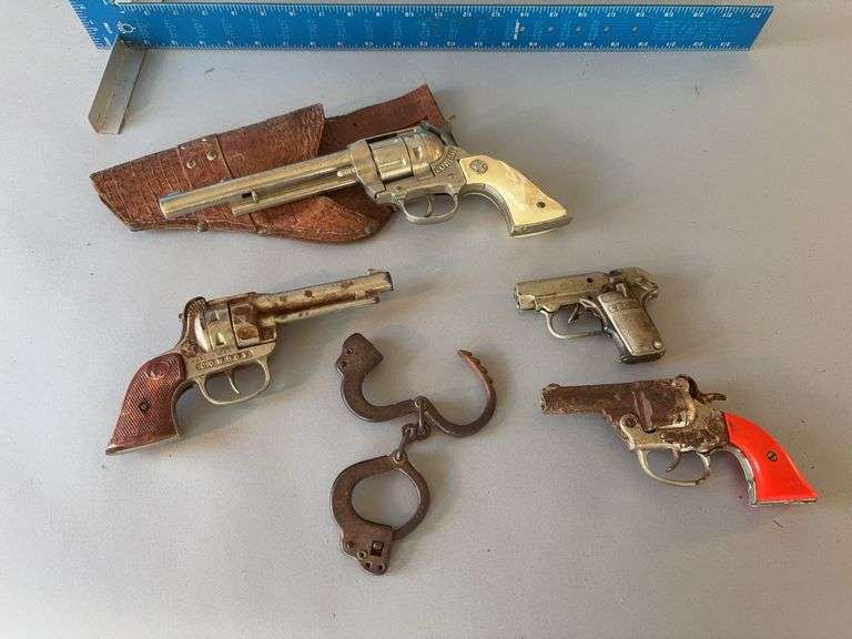 Various cap guns and a pair of handcuffs image