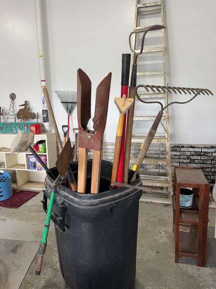 Garbage can and long handled yard tools image