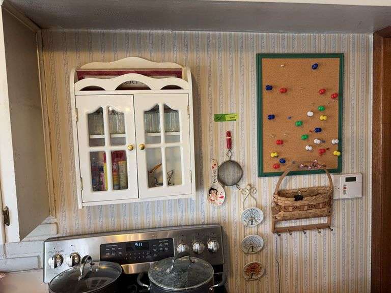 On wall includes key holder, cork board w tacks, spice cupboard & contents, etc image
