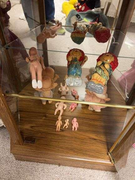 Bottom 2 shelves of curio include paper mache Raggedy Anne and Andy, hard plastic dolls including some jointed and one w sleep eyes image
