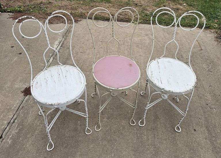 Three soda fountain chairs and one mismatched iron chair with no seat image