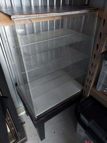 Glass Display Cases. Open-back glass display case on wood legs measures 46.75"H x 24"W x 17.5"D overall. Hexagonal case measures 18"x10"x9" and missing door latch. image