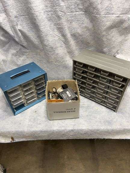 Lot consisting of two storage drawer cabinets - first cabinet 24 drawers, 12 in wide by 10.5-in high by 6 in deep, second unit 15 drawers one missing 10 in wide by 8 in high by 6.25 in deep. Box of miscellaneous pulleys. Plumbing items. Hinges. Casters. image