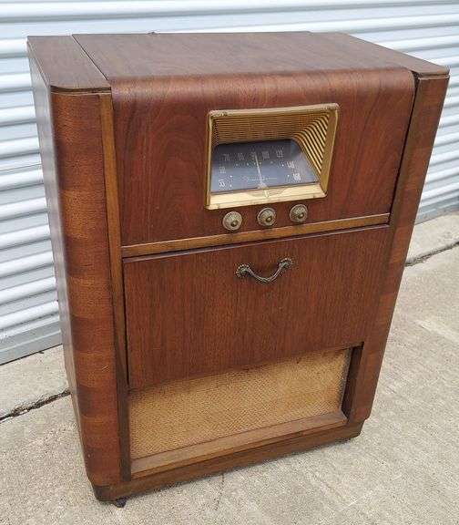 Vintage Console Radio Phonograph, either Philco or Zenith (can't find any exact matches). Guts are intact but inoperable, including record player and Stewart Warner Radio Model A61CR21. Veneer is in very good condition considering this is ca.1940s/50s, minor damage/defects noted in photos. Has original casters but they're pretty chewed up and don't roll very well. NO BACK PANEL INCLUDED. Dimensions: 26.5"W x 16"D,
35.5"H w/casters (34-1/8"H w/o casters) image