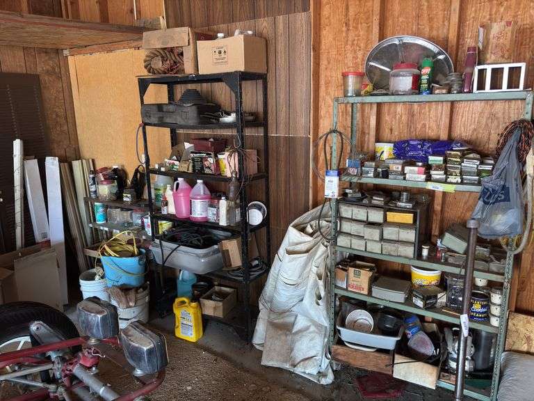 Back wall of garage includes lots of assortment bins, shelving units, hardware, nuts and bolts a few tools image