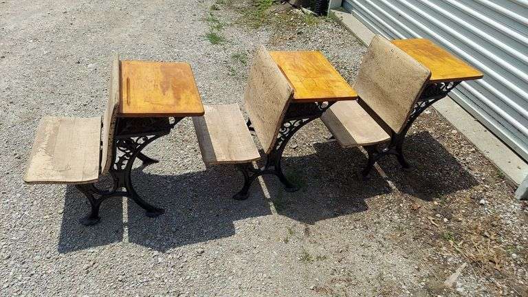 Set 3 Antique Student Desks. Date Range: 1900-1909. Turn-of-the-Century School House Desks, wrought iron & solid wood-slat construction, bench seats fold up. All in overall GOOD condition, functional and nothing broken. Dimensions: 24"H x 19"W x ~27"L bench seat down (~21"L folded). Includes 2 rails (see photos) that anchor the desks together (desk feet screw onto rails). image