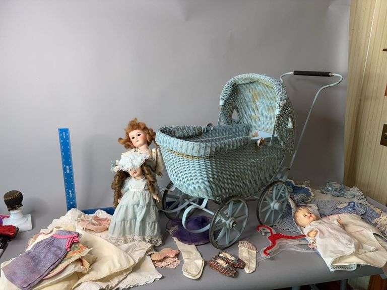 Wicker baby buggy with dolls and clothes image