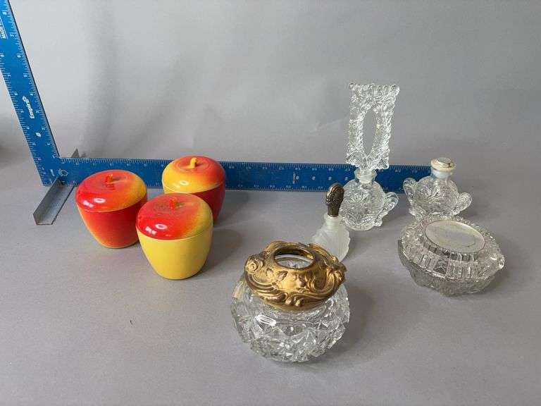 Dresser items include clear glass perfume bottles, apple trinket jars, hair receiver image
