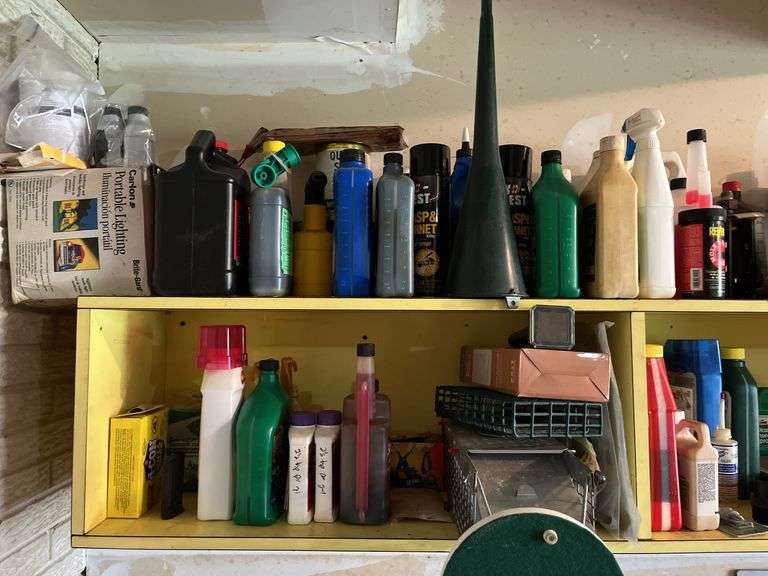 Shelves of auto and garage fluids and supplies, plus small live trap