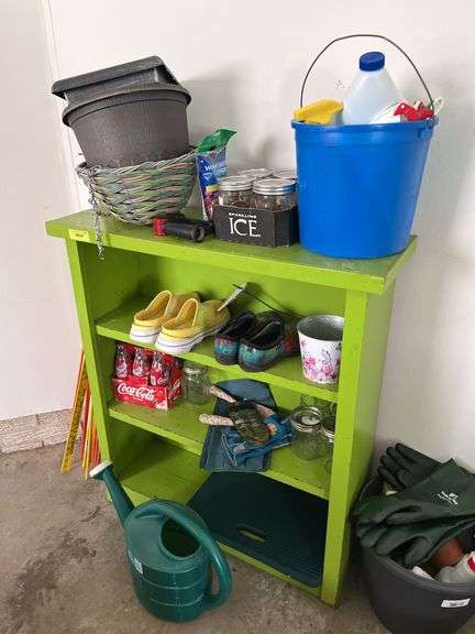 Green bookshelf and gardening items, shoes, fiberglass driveway markers, sprinkling cans etc...