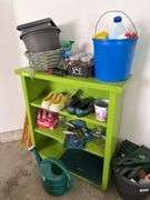 Green bookshelf and gardening items, shoes, fiberglass driveway markers, sprinkling cans etc...