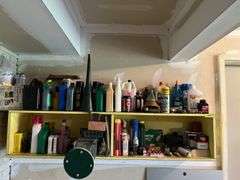 Shelves of auto and garage fluids and supplies, plus small live trap