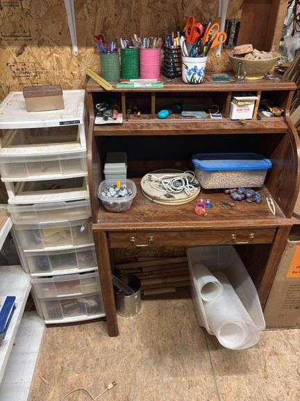 Small desk with lots of crafting items lots of tape, popsicle, sticks, rocks