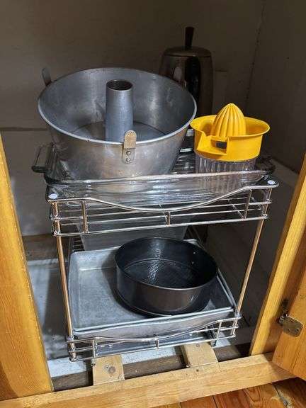 Lower cupboard contents in kitchen - bakeware, pans, colander, plasticware