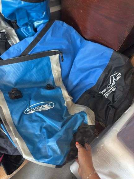 Box of water sports items, including three dry bags and some clothing